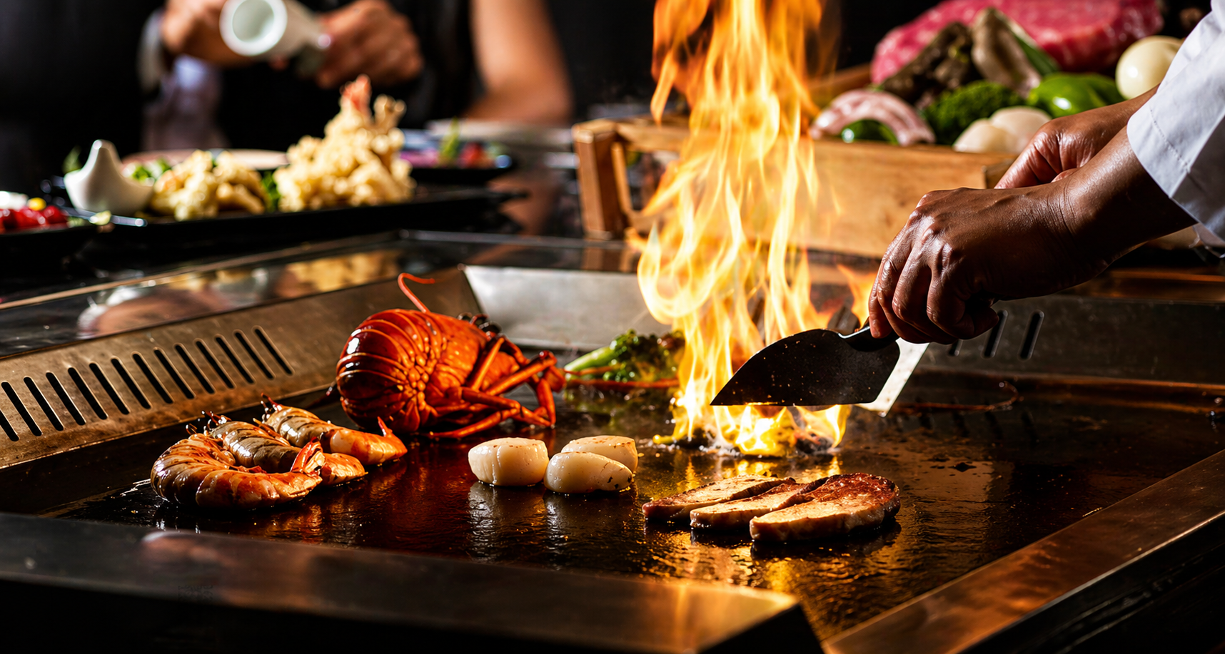 Chef en pleine cuisson teppanyaki avec flammes